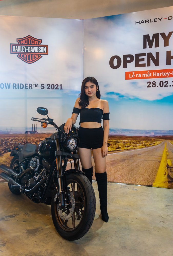 petite woman standing next Harley Davidson Low Rider